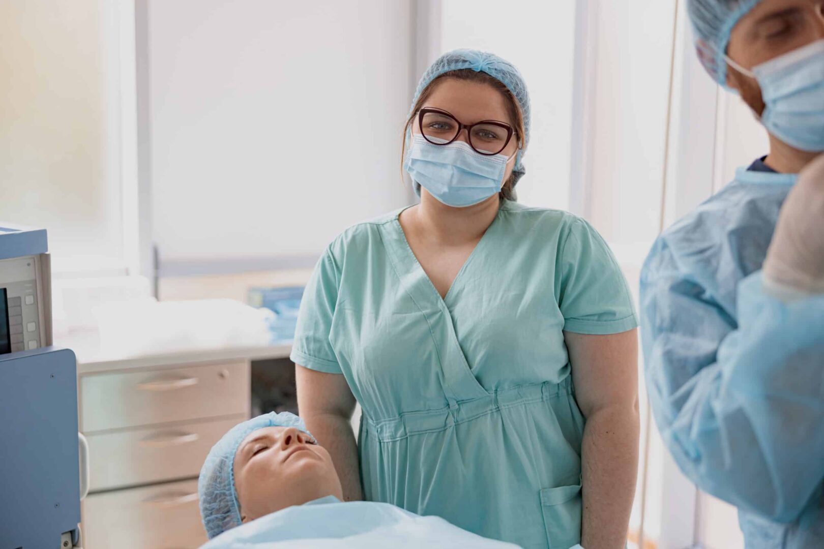 Portrait of Midwifeassisting doctors during surgery in operation room of modern clinic